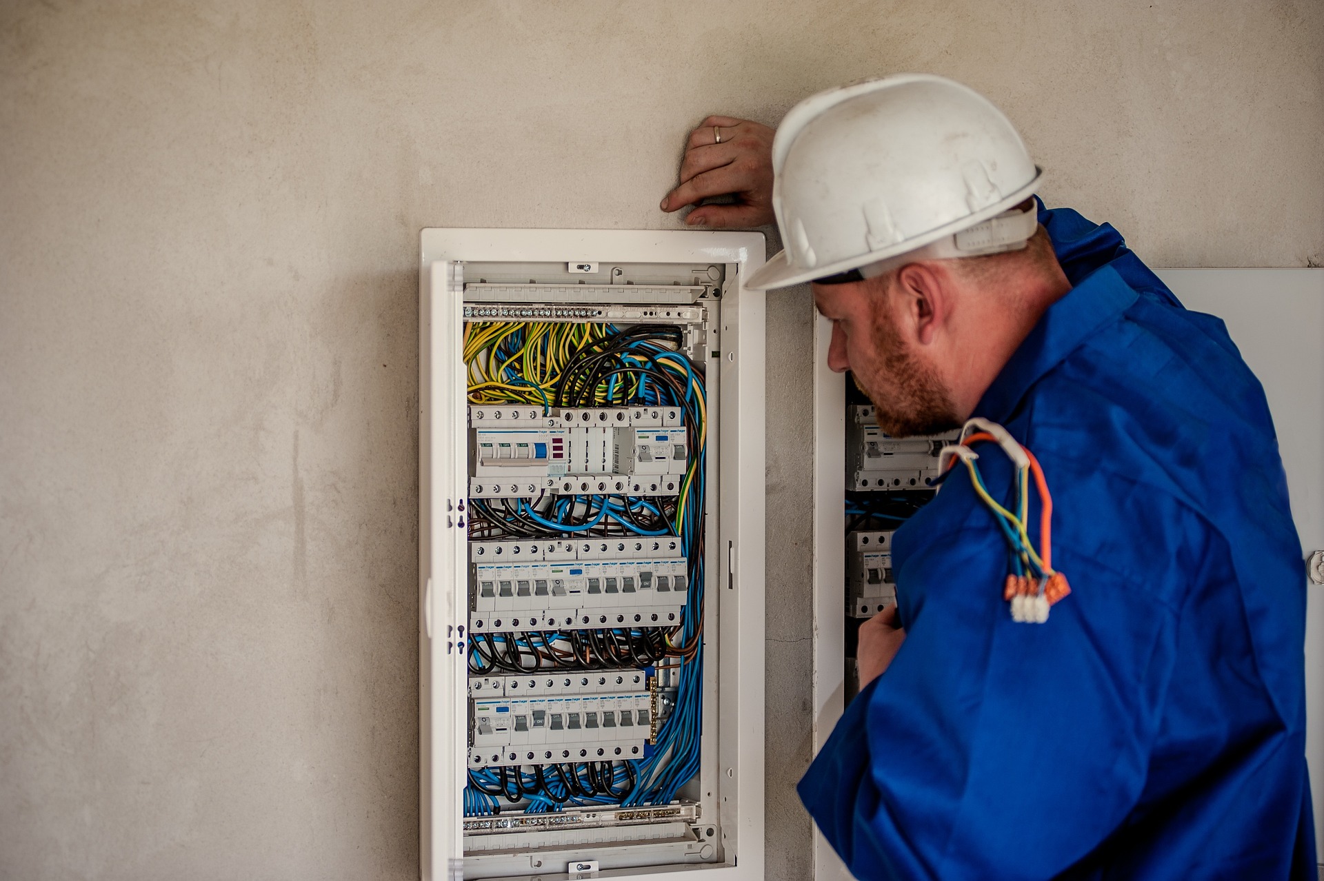 Bilden visar en elektriker som utför ett service arbete vid elskåp. AMA VVS & Kyla 19 har nu ersatts med AMA VVS & Kyla 22.